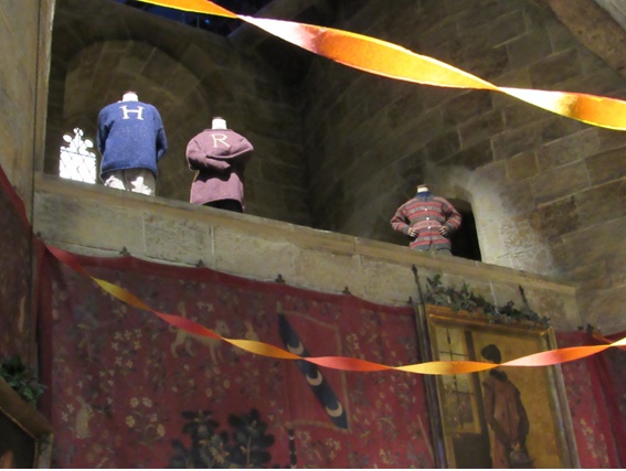Roupas utilizadas pelo trio de protagonistas em HP e a Pedra Filosofal no Salão Comunal da Grifinória.